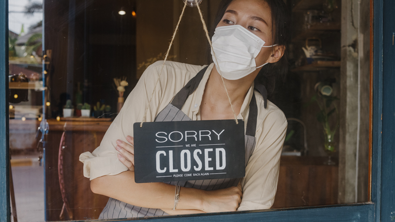 摄图网_306783229_年轻亚洲女孩在冠状封闭隔离后戴着面罩将玻璃门咖啡厅的标志从开放变为封闭标志（企业商用）.jpg
